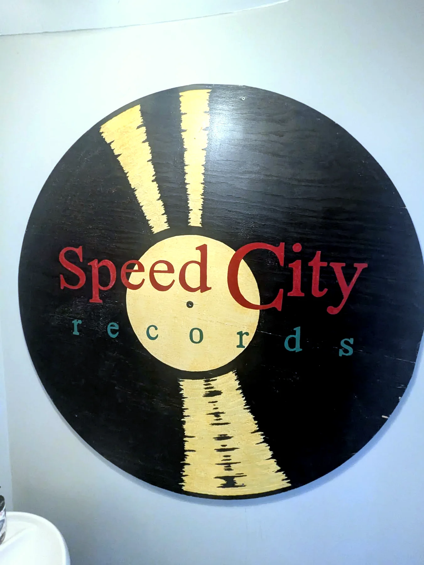 The hand painted Speed City Records record logo sign on the shop wall